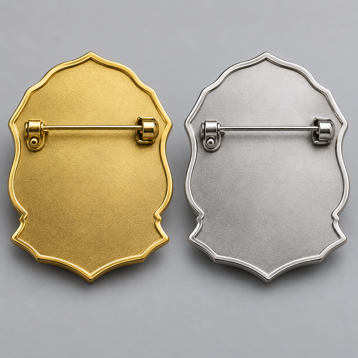 Rear views of gold and silver remembrance brooches showing their traditional safety pin-style clasp
