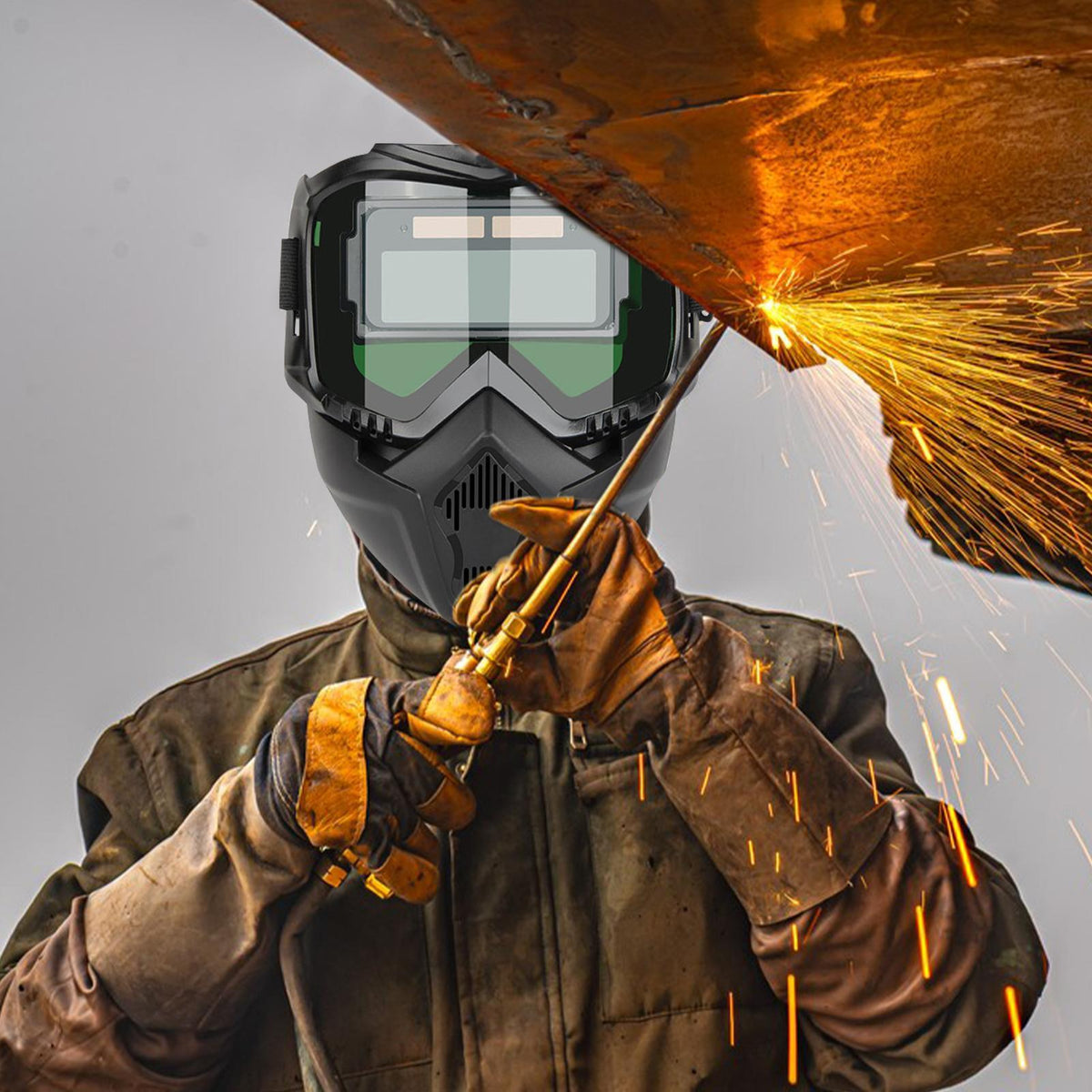 Worker wearing auto-darkening welding mask during welding operation