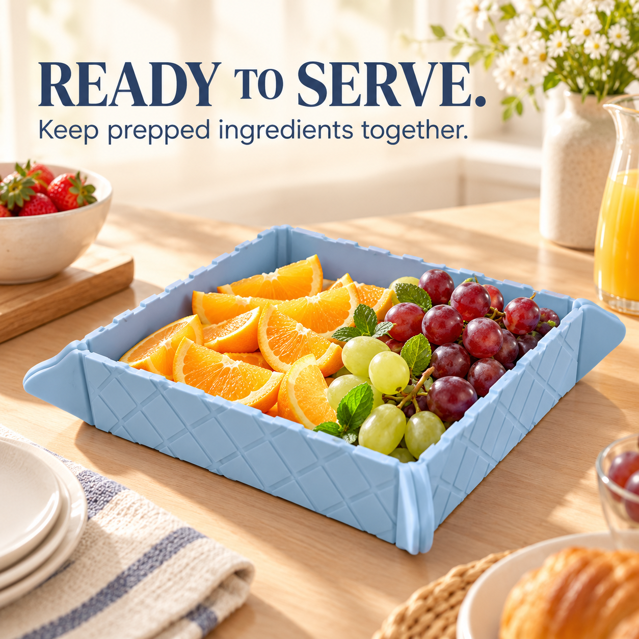 Blue folded tray serving orange slices and grapes at a breakfast table