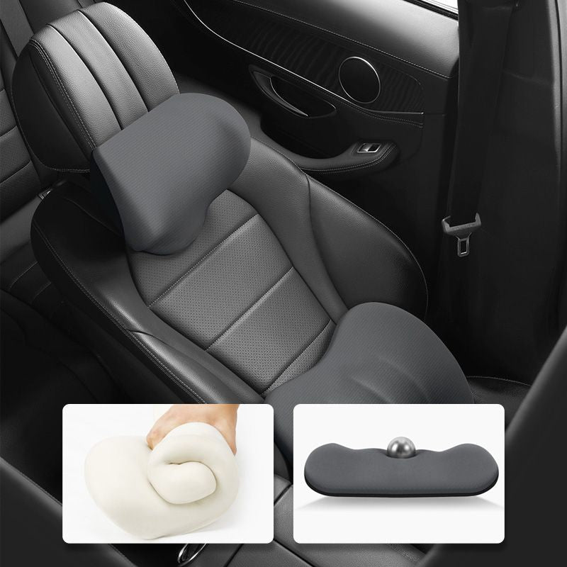 Grey ergonomic headrest and lumbar cushions positioned on a vehicle seat